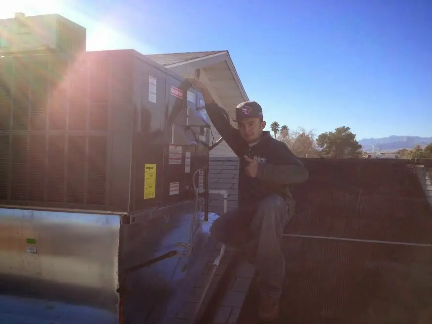 HVAC technician performing Heat Pump Repair on a rooftop unit in Voorhees