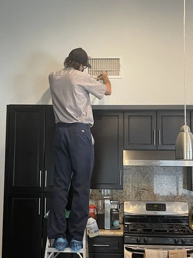 Technician inspecting an air vent during HVAC service in Voorhees